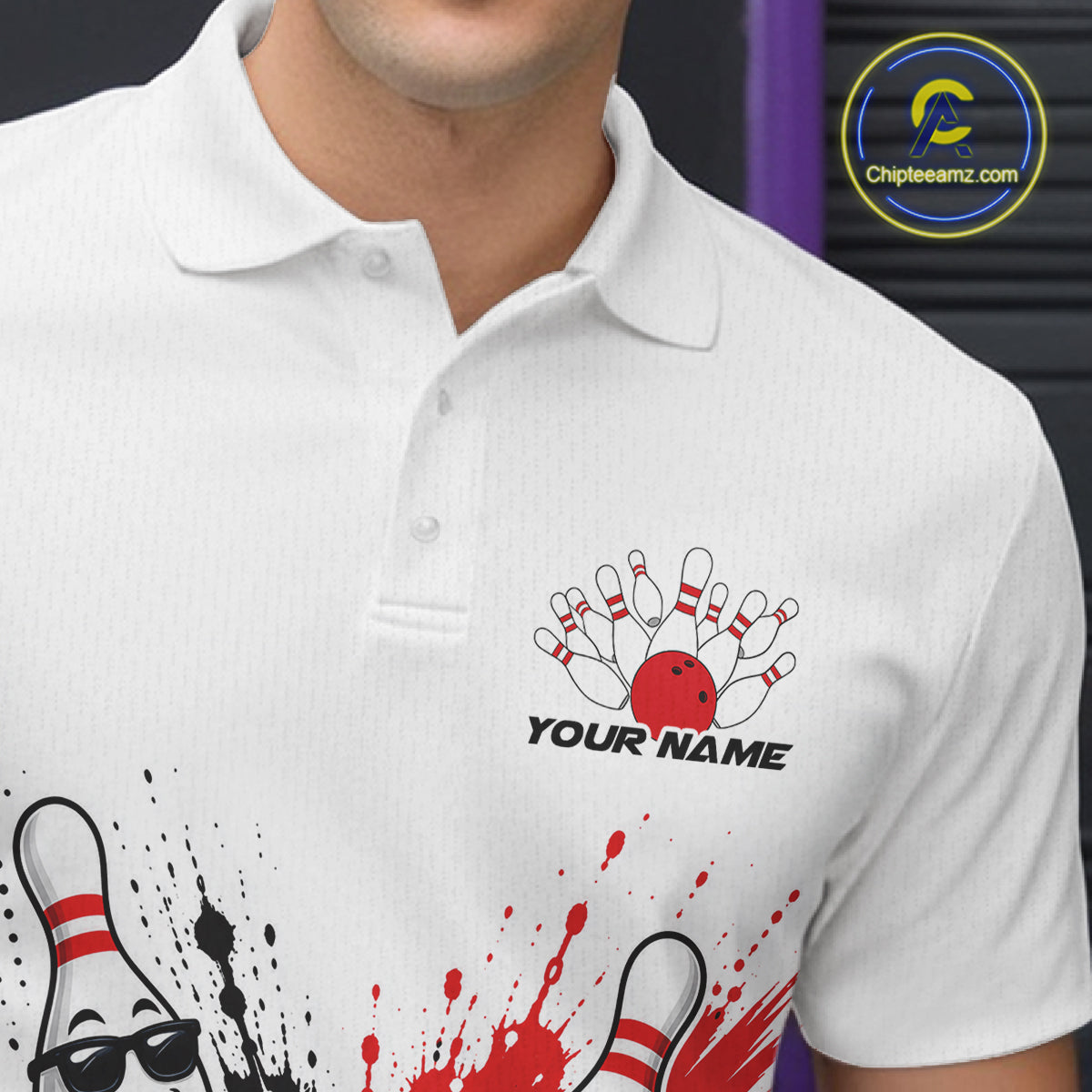 White short-sleeve polo shirt with bowling-themed graphic print, including a red bowling ball, pins, splatter, and the text 'YOUR NAME'. 