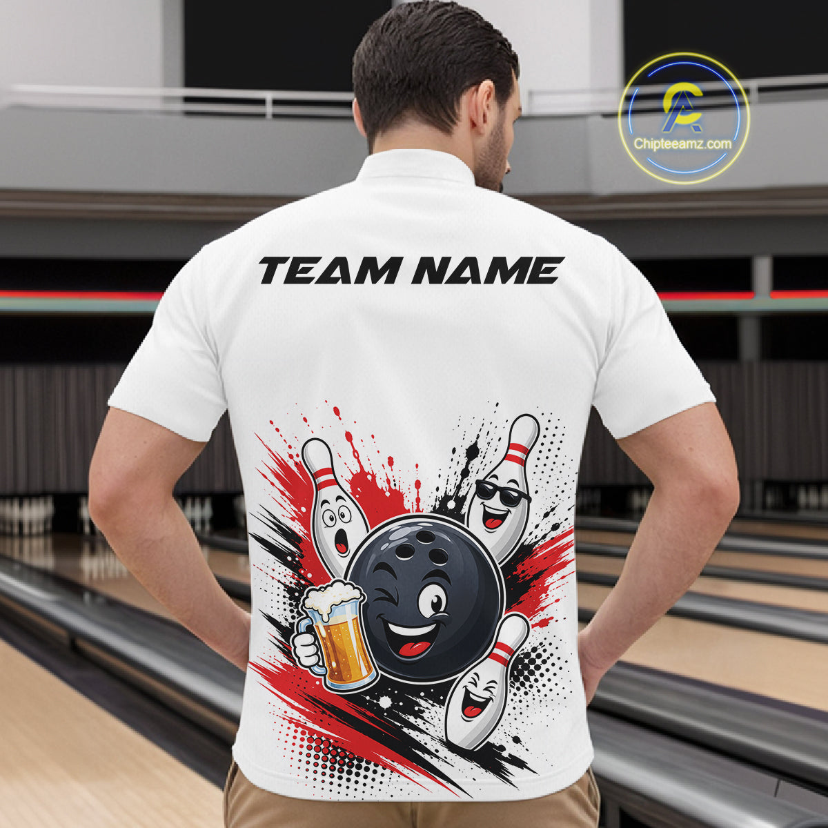 A man viewed from behind wearing a white short-sleeve bowling-themed shirt with a large graphic on the back featuring cartoon bowling pins, a bowling ball, a beer mug, and the text 'TEAM NAME'. The background shows blurred bowling lanes.