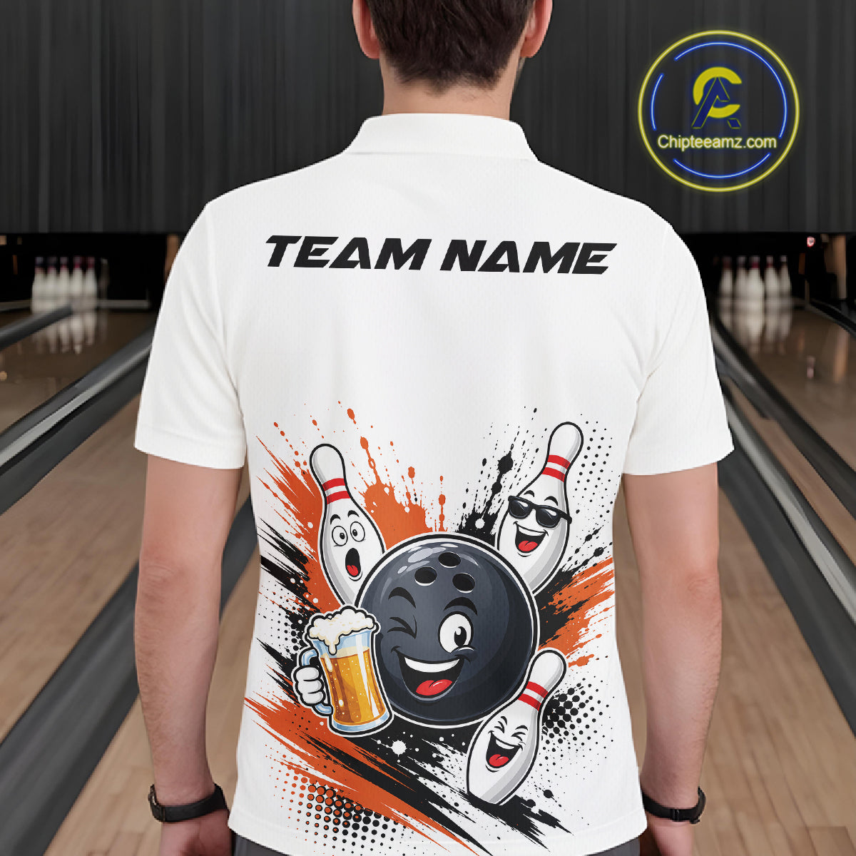 A white short-sleeve polo shirt shown from the back on a person standing in a bowling alley. The shirt features a large graphic of a cartoon bowling ball and pins with orange and black paint splatter, plus the text 'TEAM NAME' printed across the upper back.