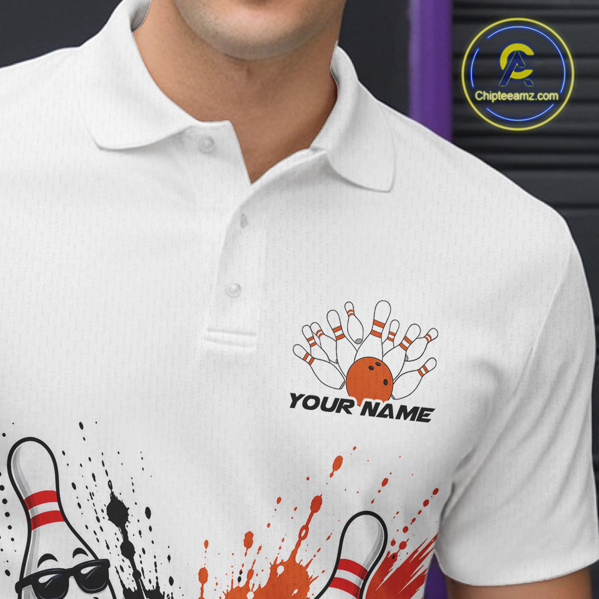 A close-up of a white polo shirt worn by a model, featuring a bowling-themed graphic with pins, an orange bowling ball, and the text 'YOUR NAME' on the chest.