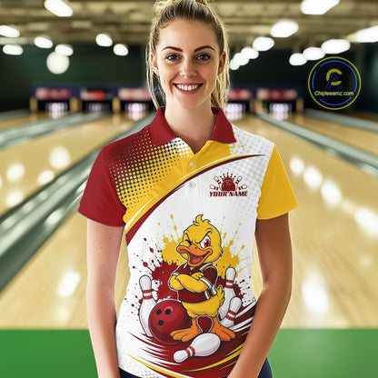 A woman stands in a bowling alley wearing a custom bowling-themed polo shirt. The shirt features a red and yellow collar, a red-to-yellow gradient on the shoulder, and a large cartoon duck mascot graphic on the front with bowling balls and pins.