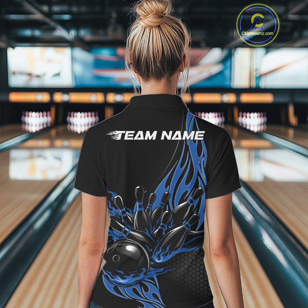 Female model seen from the back in a bowling lane wearing a black polo shirt featuring a blue flaming black bowling ball striking pins in a dynamic sports action design.