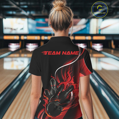 Female model back view at bowling lane wearing black and red polo shirt showcasing flame bowling ball striking pins in bold dynamic artwork.