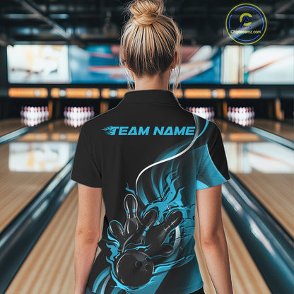 Back view female model in bowling alley wearing black and blue quarter zip shirt featuring flaming bowling ball striking pins dynamic artwork