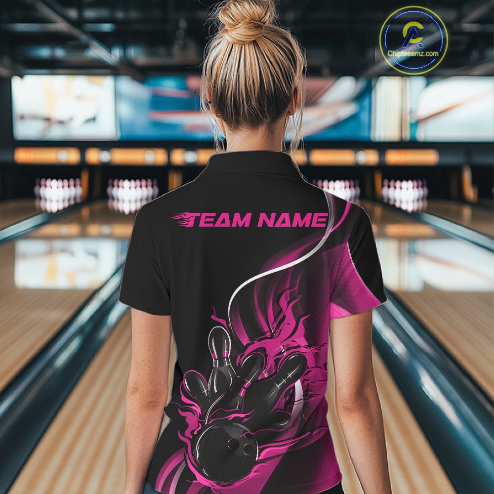 Back view female model in bowling venue wearing black and pink quarter zip shirt featuring flame bowling ball knocking down pins graphics