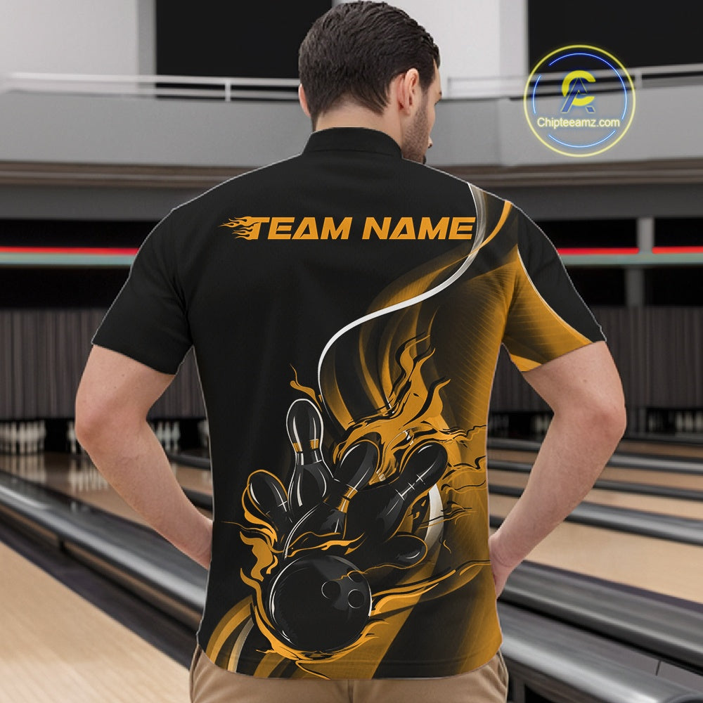 Male model front view inside bowling center wearing black and yellow quarter zip shirt featuring flaming bowling ball hitting pins artwork