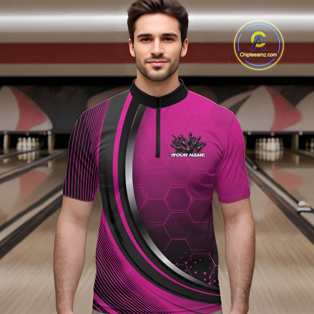 Male model in a bowling lane wearing a black and pink quarter zip shirt with honeycomb accents and a flaming bowling strike illustration.