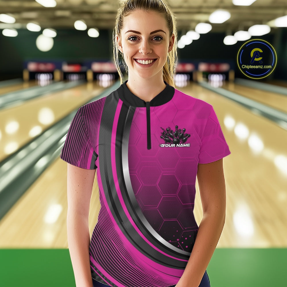Female model wearing a black and pink bowling quarter zip featuring honeycomb artwork and a flaming bowling ball striking pins at the bowling lane.