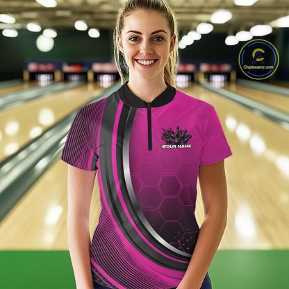 Female model wearing a black and pink bowling quarter zip featuring honeycomb artwork and a flaming bowling ball striking pins at the bowling lane.