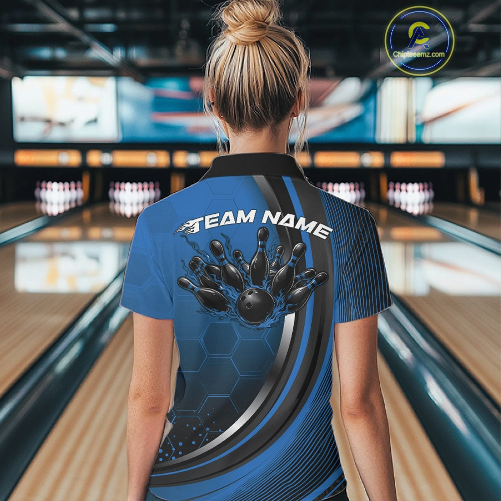 Back view of a female model in a bowling venue wearing a black and blue polo shirt, showcasing honeycomb pattern and flame bowling ball hitting pins artwork.