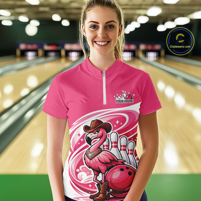 Female model wearing a pink bowling quarter-zip shirt at a bowling lane with a cowboy flamingo and bowling ball artwork.