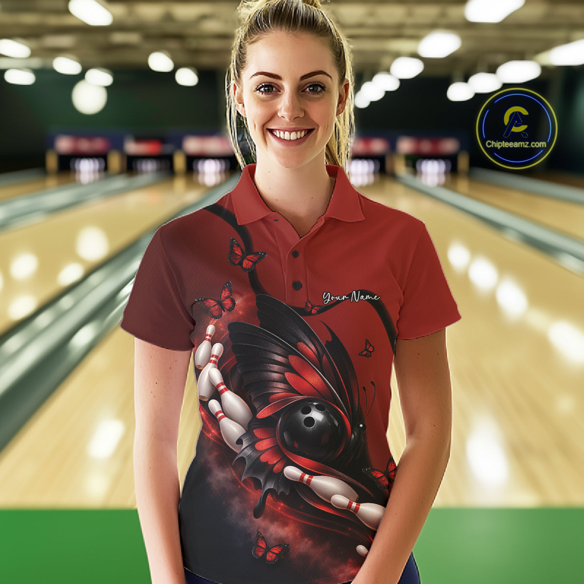Female model wearing a red and black bowling polo shirt at a bowling lane with butterfly artwork, bowling ball graphics, and pins.