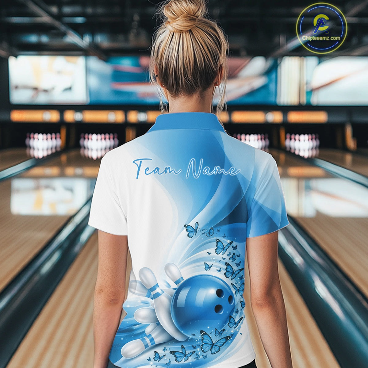 Back view of a female model wearing a white and blue bowling quarter zip with butterfly artwork and bowling graphics