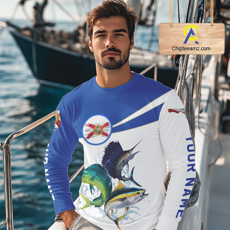Man wearing a long-sleeve shirt with fish graphics and a flag on a boat