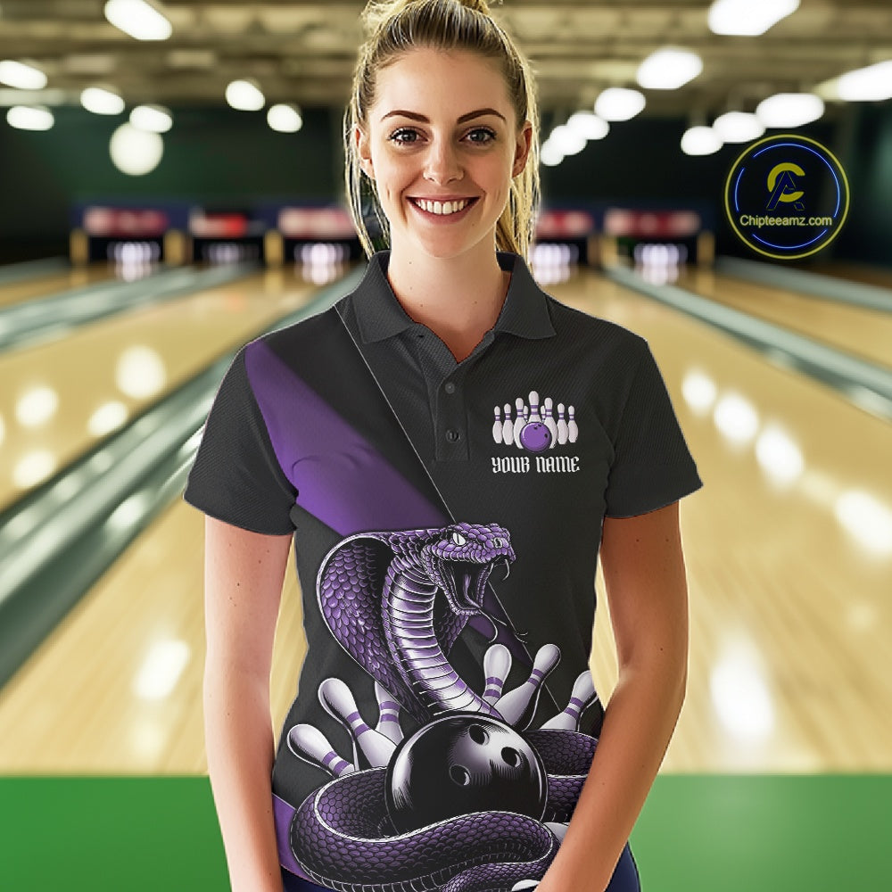 Female model wearing a black bowling polo at the bowling lane with purple cobra artwork and bowling pins.