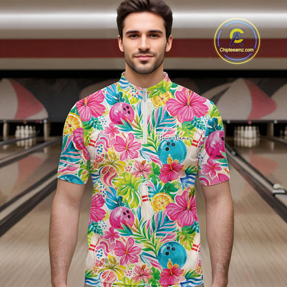 A man wearing a colorful tropical floral bowling-themed short-sleeve quarter zip shirt, standing in front of a blurred bowling alley background. The shirt features pink hibiscus flowers, blue bowling balls, and green palm leaves