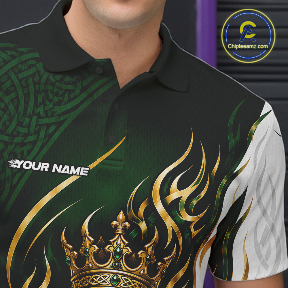 A close-up of a man wearing a short-sleeve polo shirt with a black collar, featuring a green and black tribal pattern on one side, a white patterned sleeve, and a large gold flame and crown graphic on the front. 