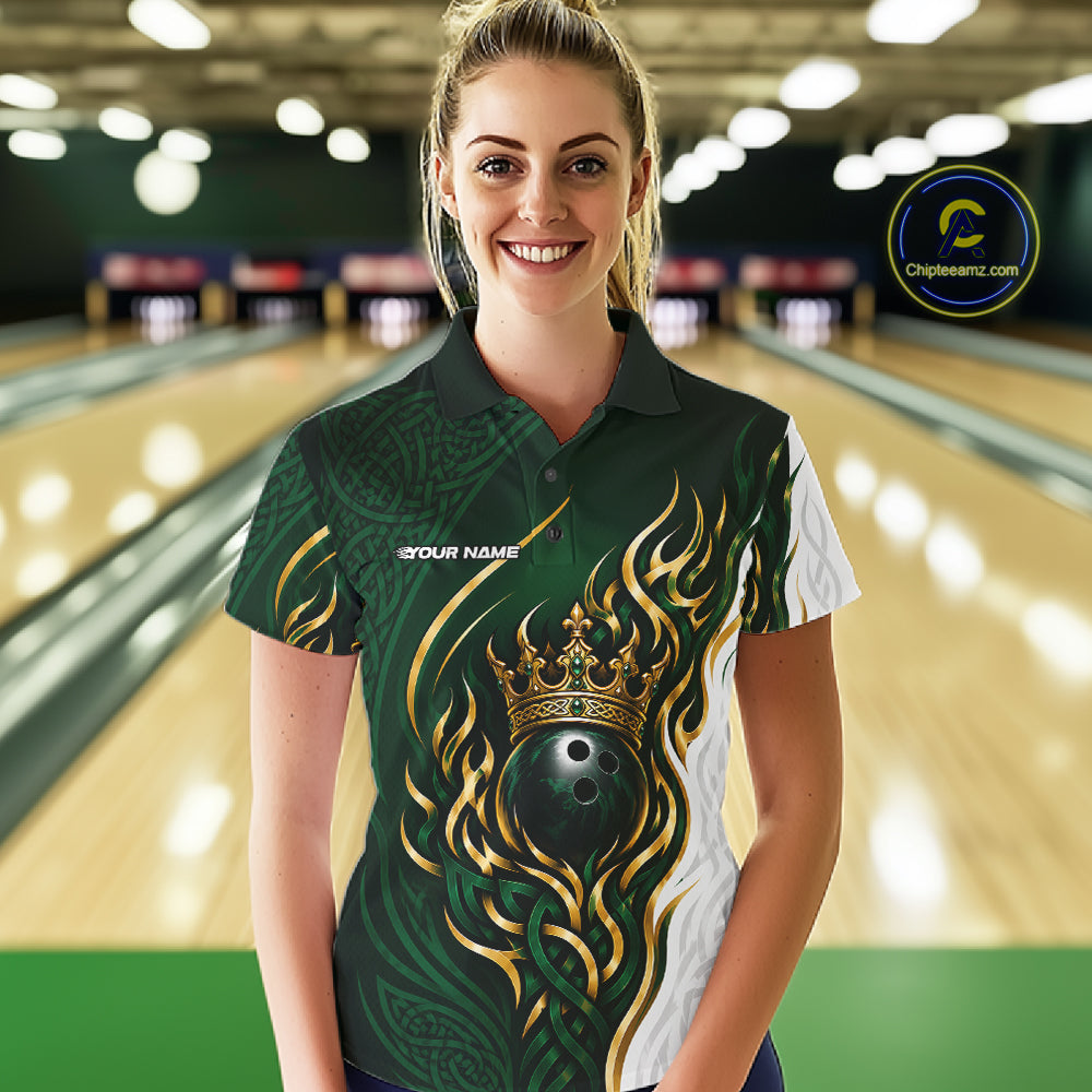 A woman stands in a bowling alley wearing a custom short-sleeve polo shirt with a green, gold, and white design featuring a crown, flame-like patterns, and a bowling ball graphic. 