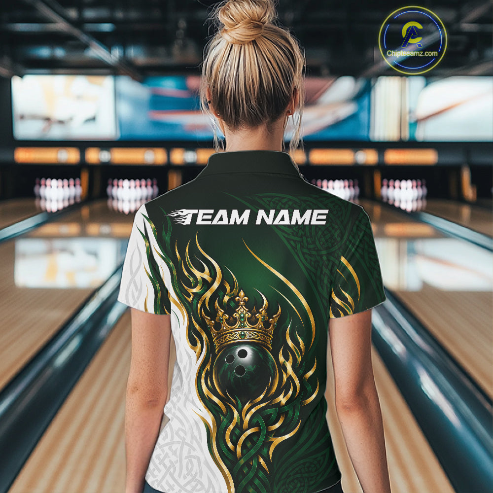A woman viewed from behind wearing a custom bowling quarter zip shirt in a bowling alley. The shirt features a dark green and white design with gold flame patterns, a crown and bowling ball graphic on the back, and 'TEAM NAME' 