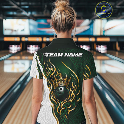 A woman viewed from behind wearing a custom bowling quarter zip shirt in a bowling alley. The shirt features a dark green and white design with gold flame patterns, a crown and bowling ball graphic on the back, and 'TEAM NAME' 