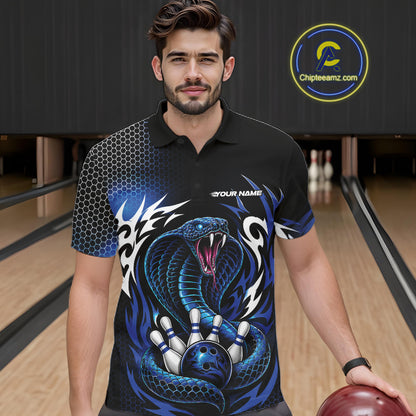 A man wearing a black short-sleeve bowling polo shirt with a blue cobra  snake graphic, standing in a bowling alley holding a bowling ball. 