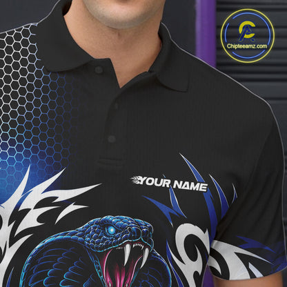 A close-up of a black short-sleeve polo shirt worn by a model, featuring a blue  coiled snake graphic on the front, tribal-style blue and white patterns, and a hexagonal grid design on the left shoulder. 