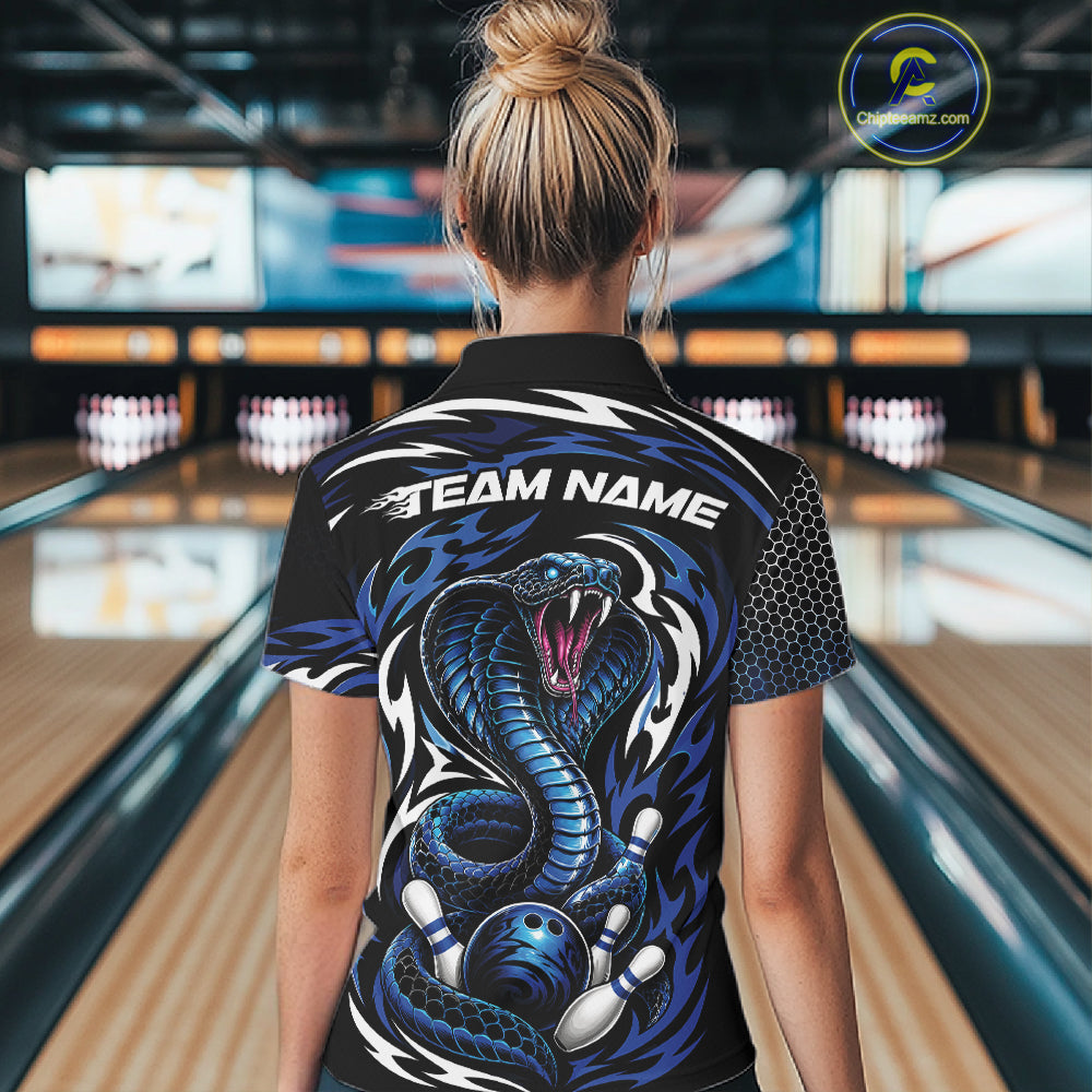 A woman viewed from behind wearing a black short-sleeve bowling polo shirt with a large blue snake graphic and the words 'TEAM NAME' across the upper back, standing in a bowling alley.