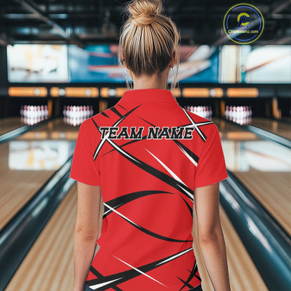 Back view of a female bowler in a bowling lane wearing a red, black, and white bowling quarter zip shirt with a sporty jersey design