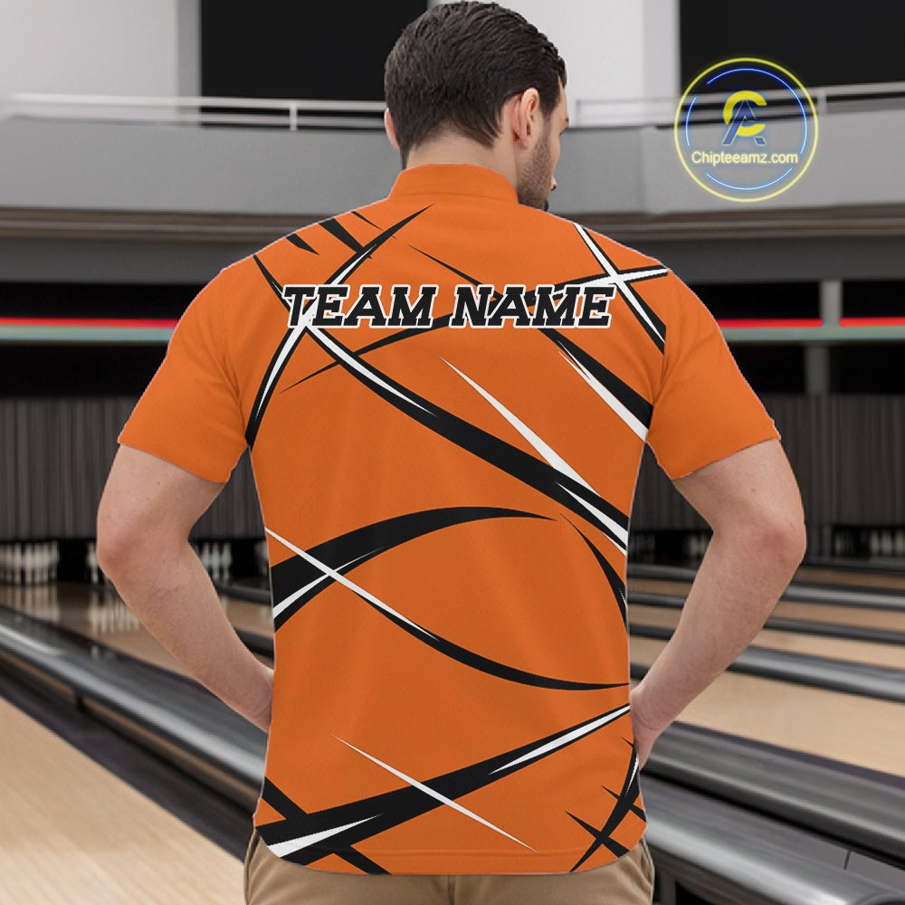 Front view of a male bowler wearing an orange, black, and white bowling quarter zip shirt in a bowling lane