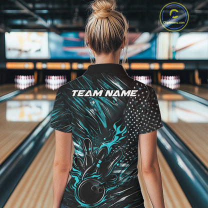 Female model at a bowling lane, back view of black and turquoise blue quarter zip shirt showcasing patriotic flames bowling ball striking pins with American flag inspired graphics