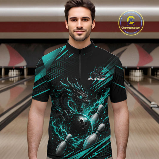 A man wearing a black short-sleeve bowling jersey with a teal and black dragon graphic, bowling pins, and a bowling alley background. 