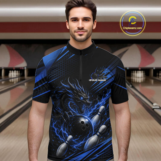 A man wearing a black and blue bowling quarter zip shirt with a dragon, bowling ball, and pins design
