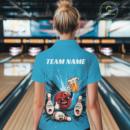 A woman viewed from behind wearing a bright blue bowling-themed short-sleeve quarter zip shirt with a large funny drunk cartoon bowling graphic and the text 'TEAM NAME' on the back, standing in a bowling alley.