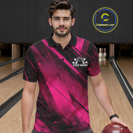 Man wearing a pink and black bowling shirt with a logo in a bowling alley.
