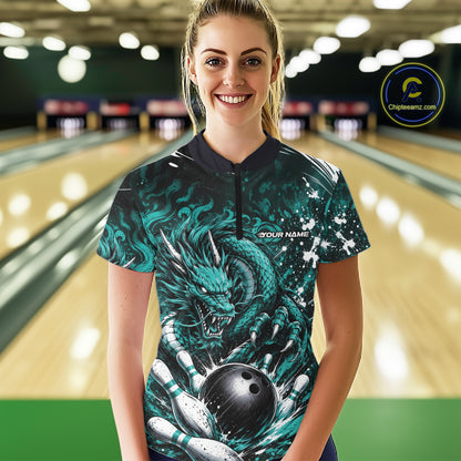 Person wearing a bowling shirt with a dragon design in a bowling alley.