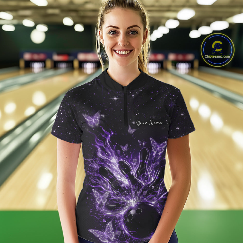 Female model wearing a black and purple bowling quarter-zip shirt at the lane with cosmic bowling strike artwork.