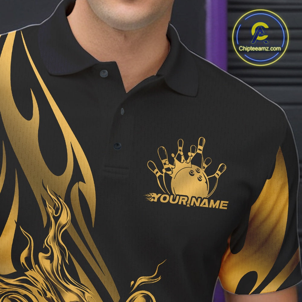 Close-up view of the left chest area of a black polo shirt showing a golden metal tribal flame bowling ball and pins design detail.