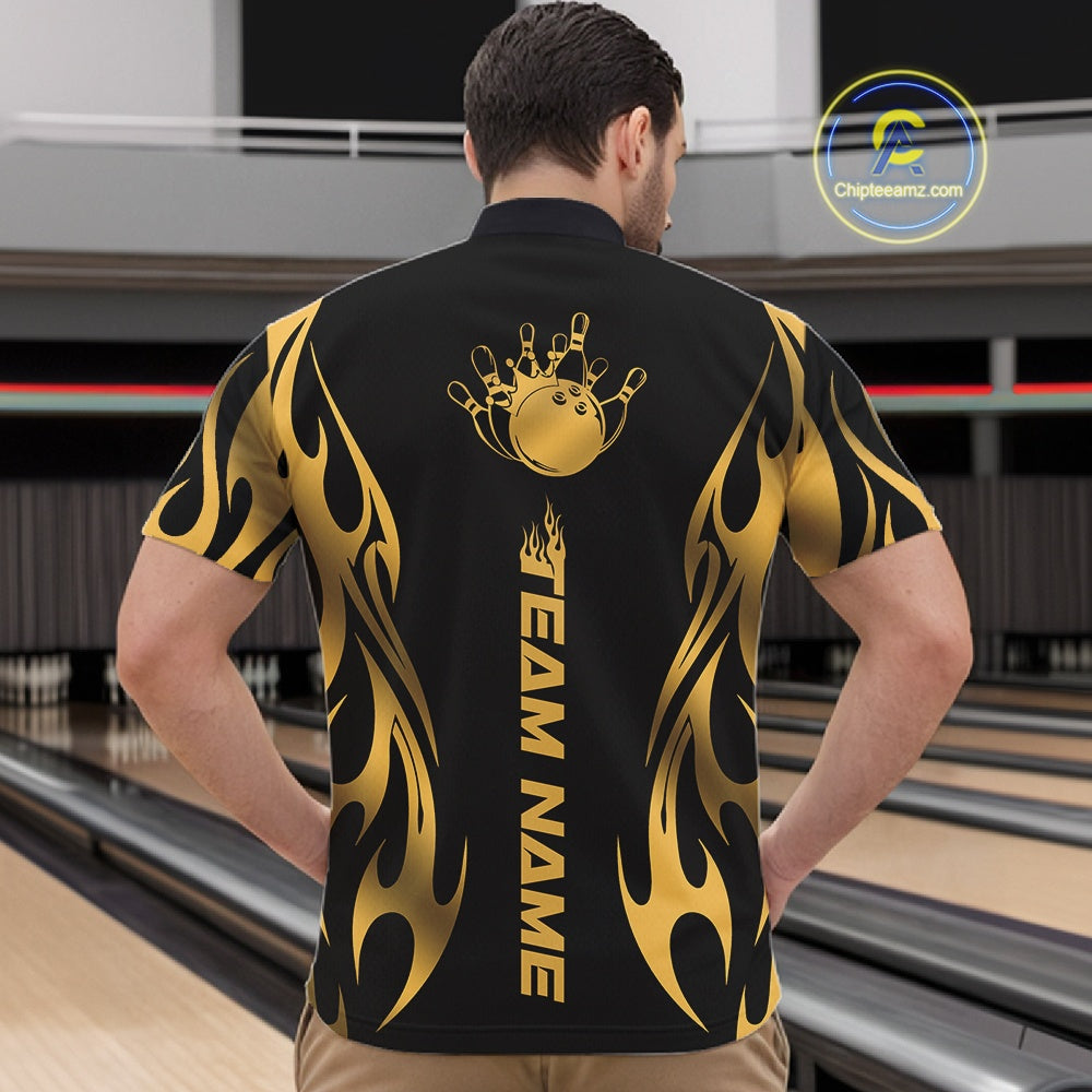 Front view male model at bowling lane wearing black quarter zip featuring golden tribal flame accents with bowling ball hitting pins in dynamic motion scene.