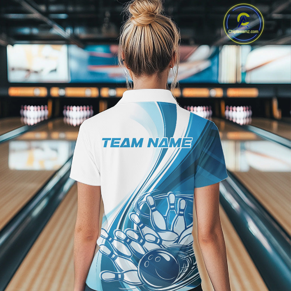 Back view of a female model in a bowling lane wearing a white and blue polo shirt, showcasing dynamic bowling ball crashing into pins artwork.