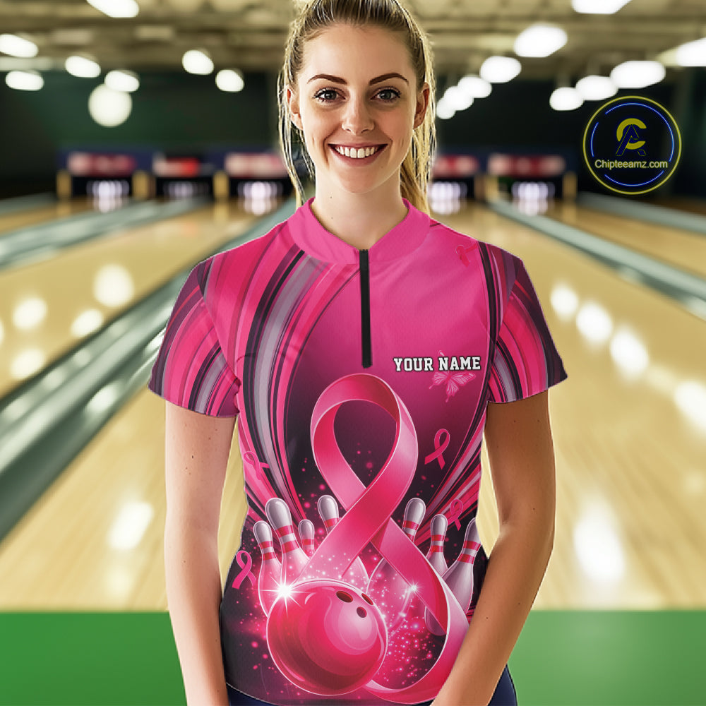 Front view of a female model wearing a pink and black bowling quarter zip featuring breast cancer awareness ribbons and bowling graphics