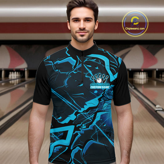 Male model wearing a black and blue quarter-zip at the bowling lane with angular geometric graphics.