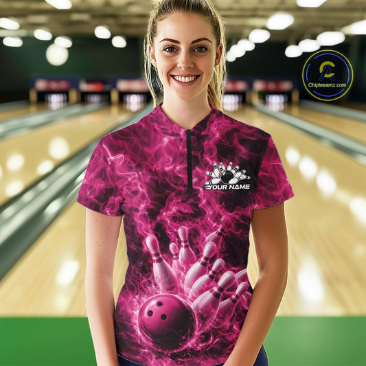 Female model wearing a bowling quarter-zip in a bowling lane featuring a pink bowling ball crashing through pins with blazing flame artwork.