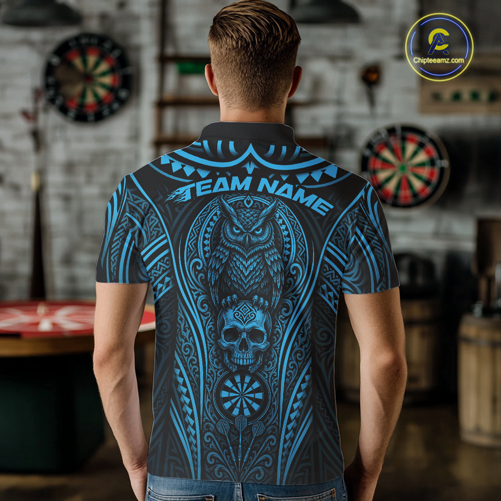 A man viewed from behind wearing a short-sleeve polo shirt with a large blue tribal-style graphic featuring an owl, skull, and dartboard motifs on a dark background.