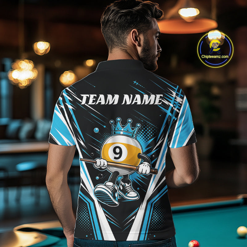 A man viewed from behind wearing a custom black and blue short-sleeve billiard polo shirt with a cartoon billiard 9-ball character and the text 'TEAM NAME'. The background is a dimly lit pool hall with a pool table visible.