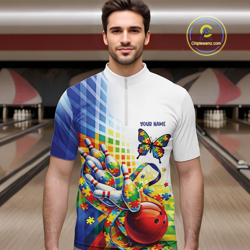 Male model in a bowling lane wearing a white and blue quarter-zip shirt, puzzle butterfly and swirling ribbon bowling artwork with colorful accents.