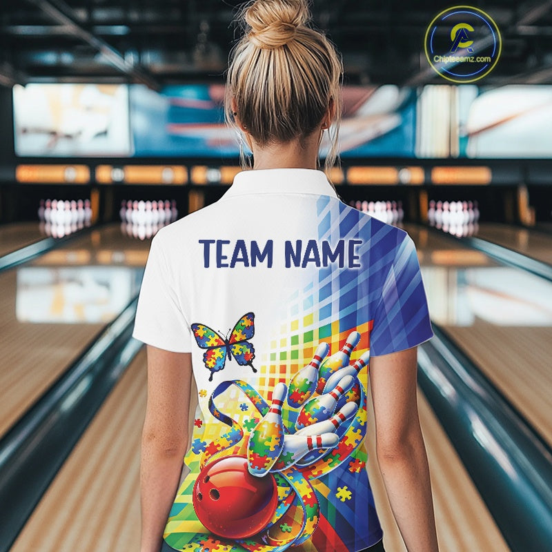 Back view of a female bowler wearing a white and blue quarter-zip shirt, swirling puzzle ribbon and bowling-themed butterfly illustration.