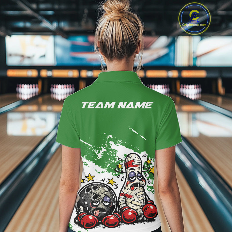 Back view of a female bowler in a green and white quarter-zip shirt, cartoon boxing bowling ball and pin design highlighted on the back.
