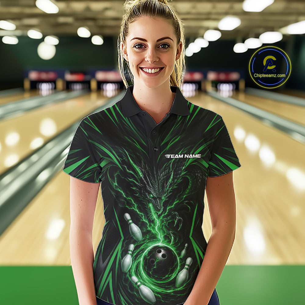 A woman wearing a black short-sleeve bowling-themed polo shirt with green lightning and bowling pin graphics, standing in front of a blurred bowling alley background.