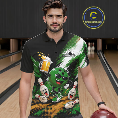 A man wearing a black short-sleeve polo shirt with a green and white bowling-themed graphic print, standing in a bowling alley holding a bowling ball. The shirt features a cartoon bowling ball character, bowling pins, and a beer glass