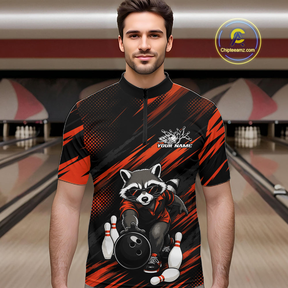 A man wearing a short-sleeve bowling-themed quarter-zip shirt with a raccoon graphic and orange diagonal stripes on a bowling alley background. 